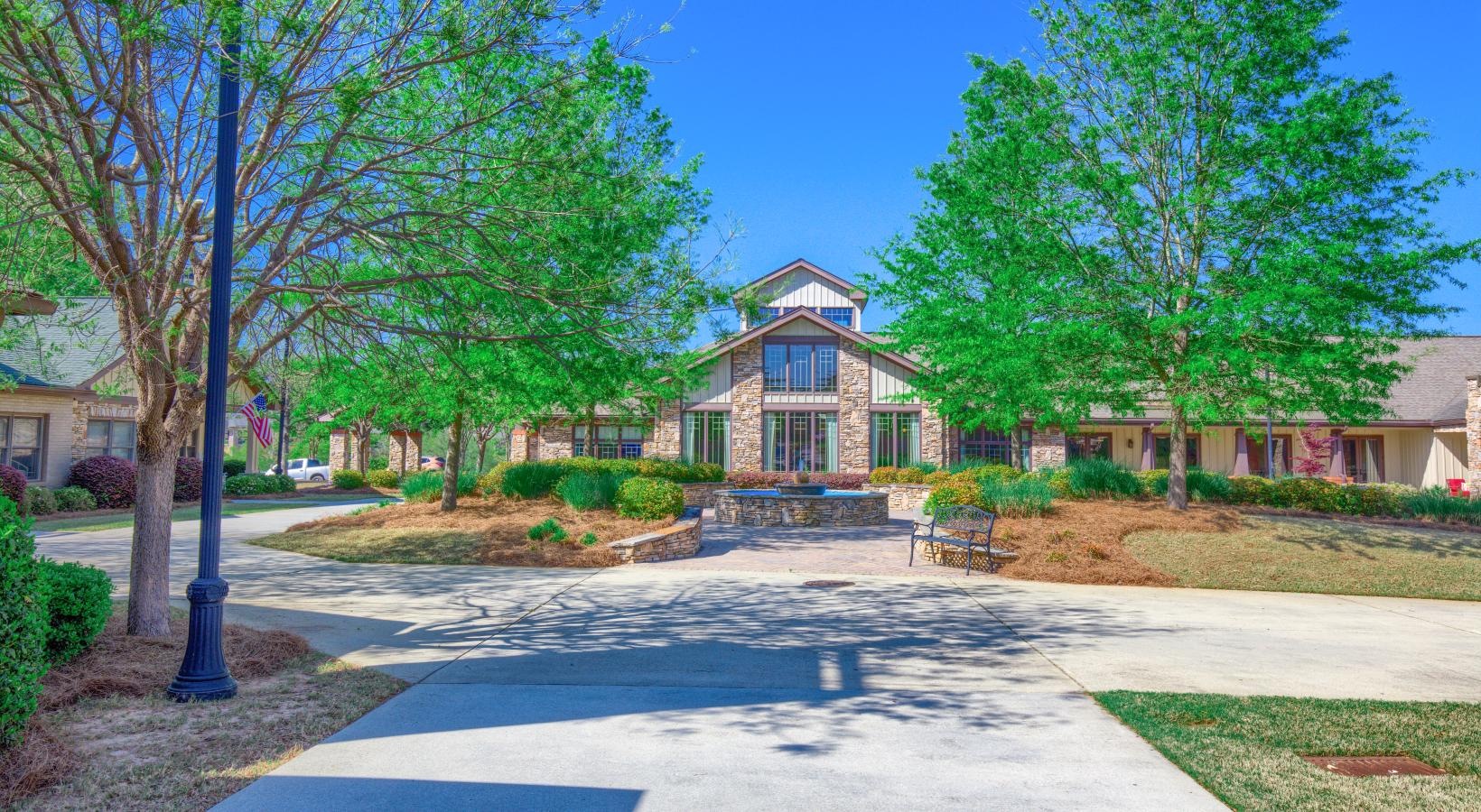 Settle into comfort at King's Reserve Suwanee a large house with trees and a driveway